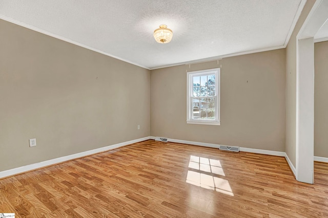 empty room with visible vents, baseboards, light wood-style flooring, crown molding, and a textured ceiling