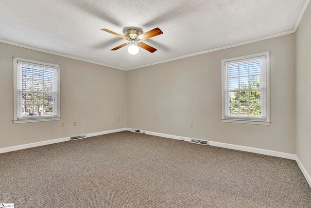 empty room with carpet floors, ornamental molding, visible vents, and a healthy amount of sunlight