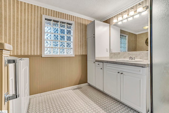 bathroom with a wainscoted wall, crown molding, and wallpapered walls