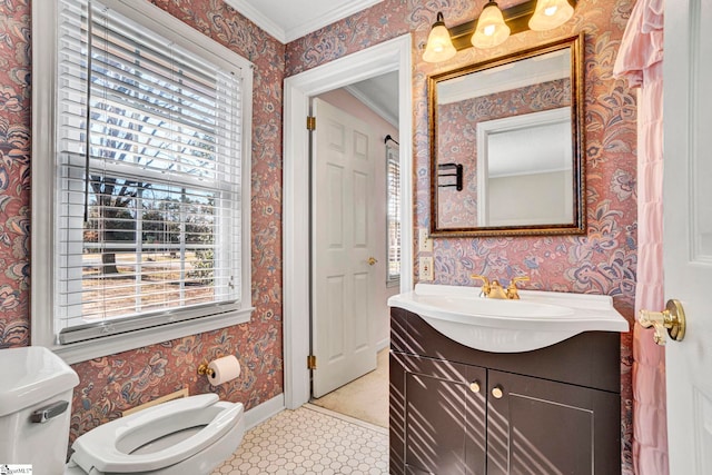 bathroom with baseboards, vanity, toilet, and wallpapered walls