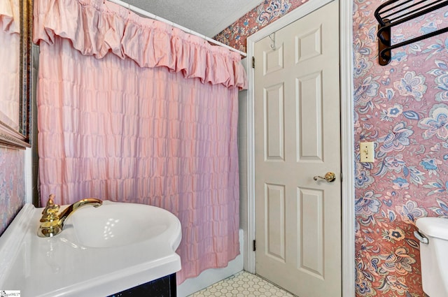 bathroom with toilet, a textured ceiling, and vanity