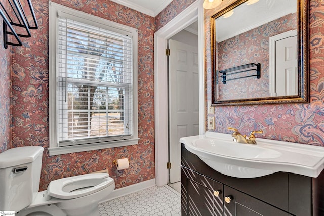 half bath with baseboards, vanity, toilet, and wallpapered walls