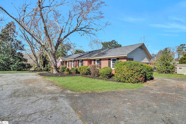 view of property exterior featuring brick siding and a lawn