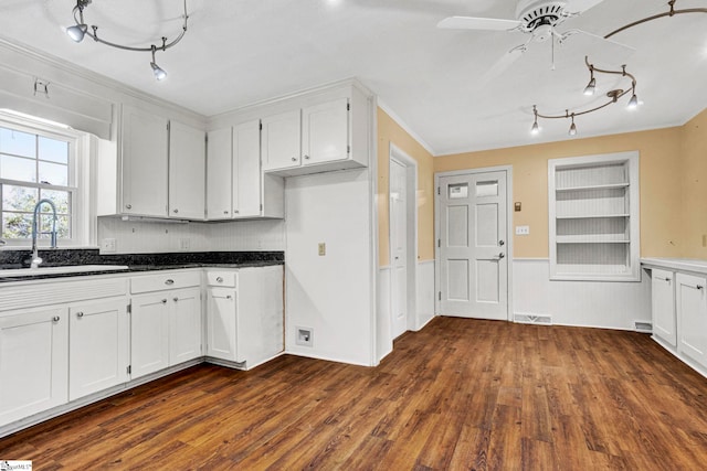 kitchen featuring built in shelves, dark wood-style flooring, dark countertops, visible vents, and a sink