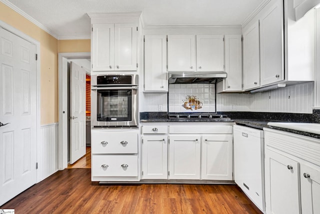 kitchen featuring stainless steel appliances, dark countertops, dark wood-style flooring, and under cabinet range hood