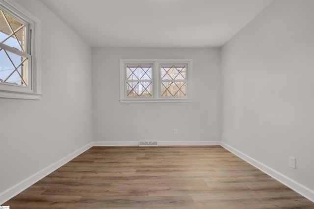 unfurnished room with wood finished floors and baseboards