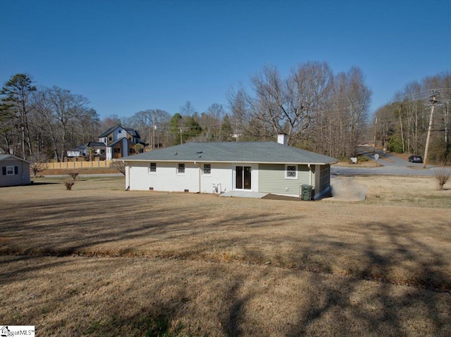 rear view of property featuring central air condition unit and a yard