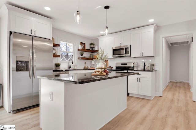 kitchen featuring tasteful backsplash, appliances with stainless steel finishes, light wood-type flooring, white cabinetry, and open shelves