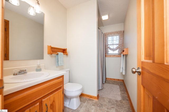 full bathroom featuring a textured ceiling, curtained shower, toilet, vanity, and baseboards