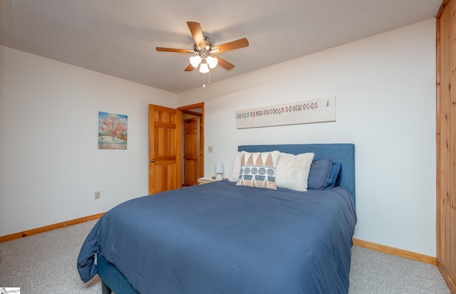 carpeted bedroom with a ceiling fan and baseboards