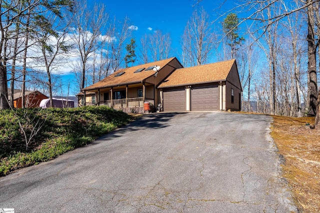 view of front of house with a garage, driveway, and a porch