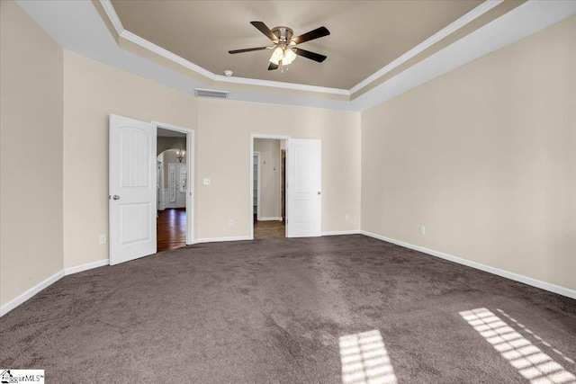 unfurnished bedroom featuring baseboards, a raised ceiling, carpet, and crown molding