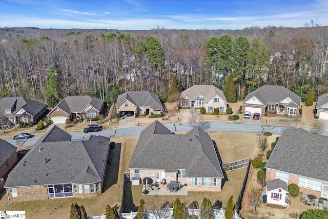 bird's eye view featuring a wooded view and a residential view