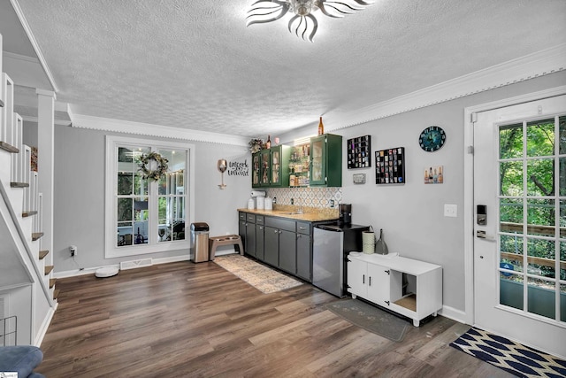 interior space with visible vents, stairs, wet bar, tasteful backsplash, and dark wood finished floors