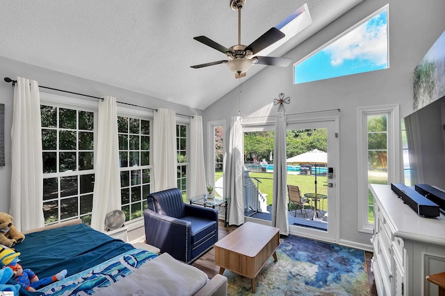 bedroom with access to exterior, ceiling fan, vaulted ceiling, a textured ceiling, and wood finished floors