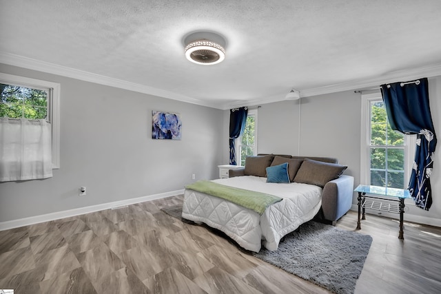 bedroom featuring ornamental molding, a textured ceiling, and baseboards