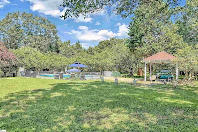 view of yard featuring fence, a fenced in pool, and a gazebo