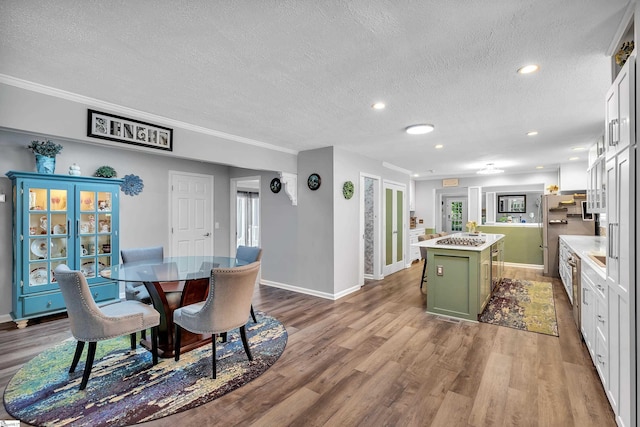 dining space featuring crown molding, recessed lighting, a textured ceiling, wood finished floors, and baseboards