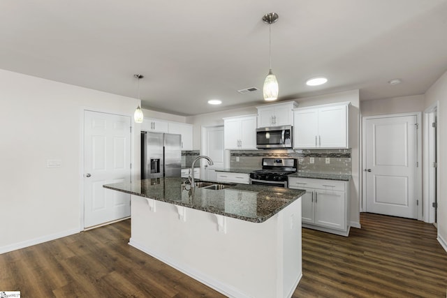 kitchen featuring dark wood-style floors, tasteful backsplash, stainless steel appliances, and a sink