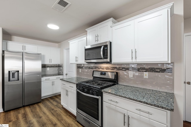 kitchen featuring dark wood-style floors, visible vents, appliances with stainless steel finishes, white cabinets, and dark stone counters