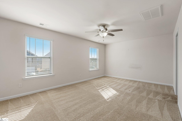 unfurnished room featuring light colored carpet, visible vents, and baseboards