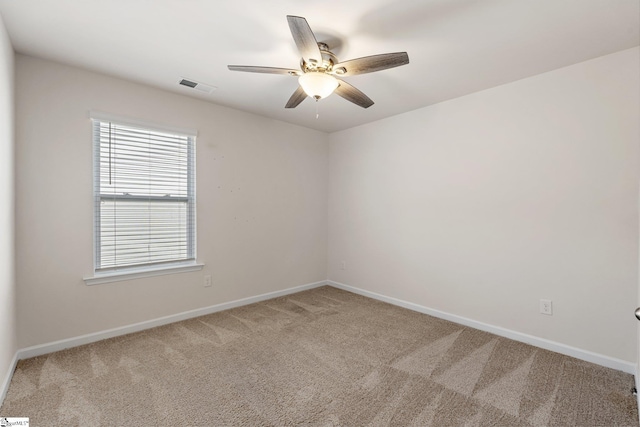 unfurnished room with carpet floors, baseboards, visible vents, and a ceiling fan