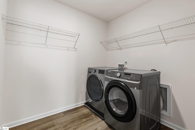 washroom featuring laundry area, independent washer and dryer, baseboards, and wood finished floors