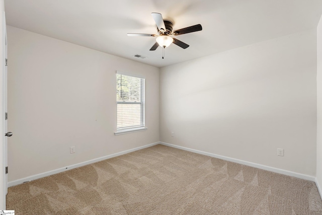 unfurnished room with visible vents, baseboards, a ceiling fan, and light colored carpet