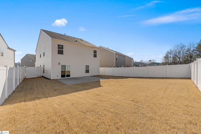 rear view of property with a fenced backyard, a lawn, and a patio