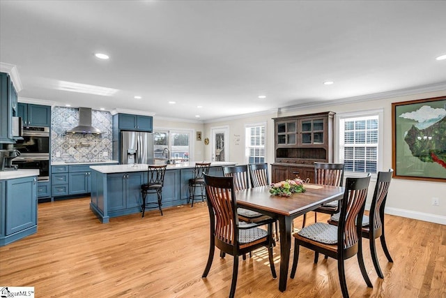 dining space featuring baseboards, ornamental molding, recessed lighting, and light wood-style floors