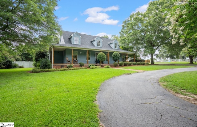 cape cod home featuring covered porch, fence, aphalt driveway, and a front yard