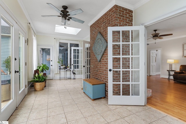 sunroom with french doors, a skylight, a wealth of natural light, and a ceiling fan