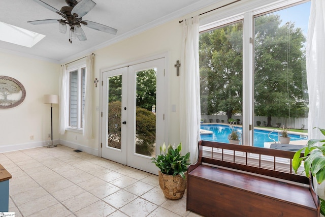 doorway with french doors, ornamental molding, a skylight, and a healthy amount of sunlight