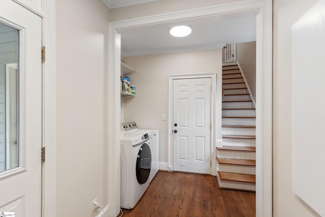 clothes washing area with laundry area, baseboards, washer and dryer, ornamental molding, and dark wood finished floors