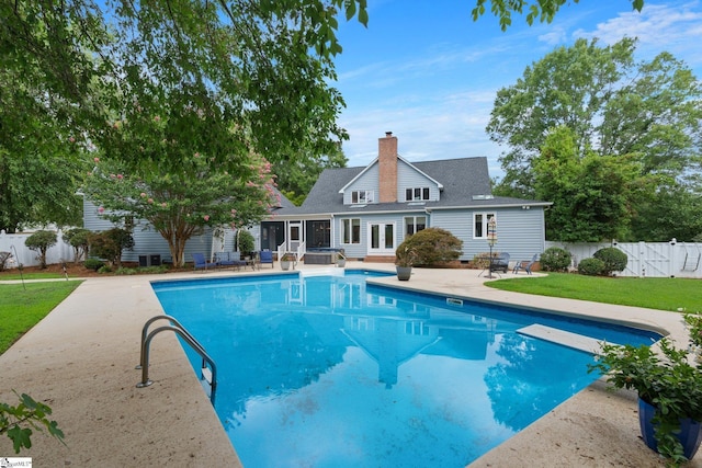 view of pool featuring a yard, a fenced backyard, a patio, and french doors