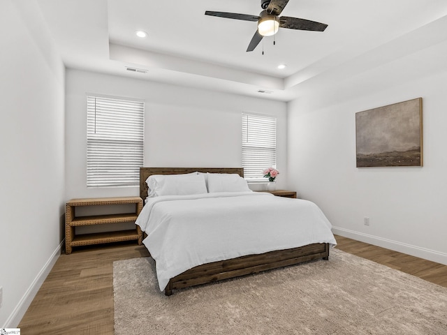 bedroom with visible vents, baseboards, wood finished floors, and recessed lighting