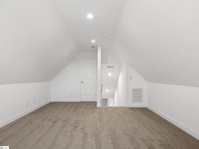 additional living space with carpet, recessed lighting, visible vents, vaulted ceiling, and baseboards