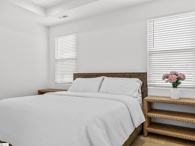 bedroom featuring visible vents and wood finished floors