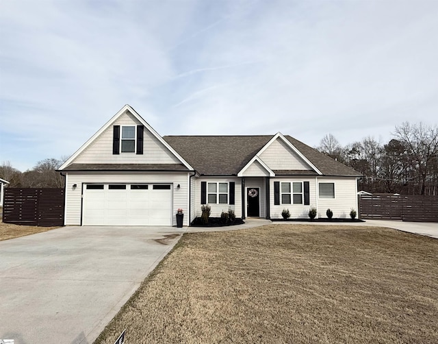 view of front of property featuring driveway, a garage, roof with shingles, fence, and a front lawn