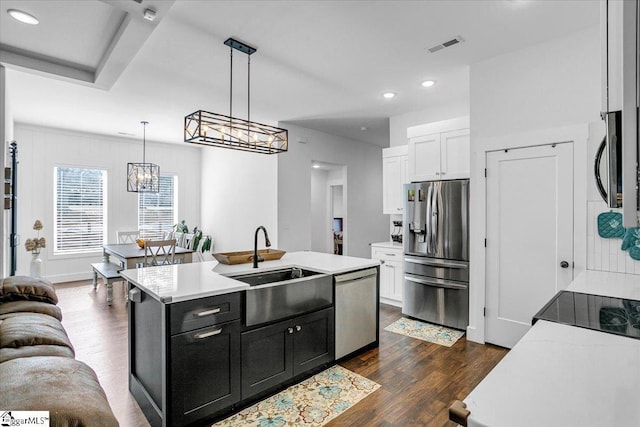 kitchen featuring dark wood-style floors, stainless steel appliances, dark cabinetry, light countertops, and white cabinetry