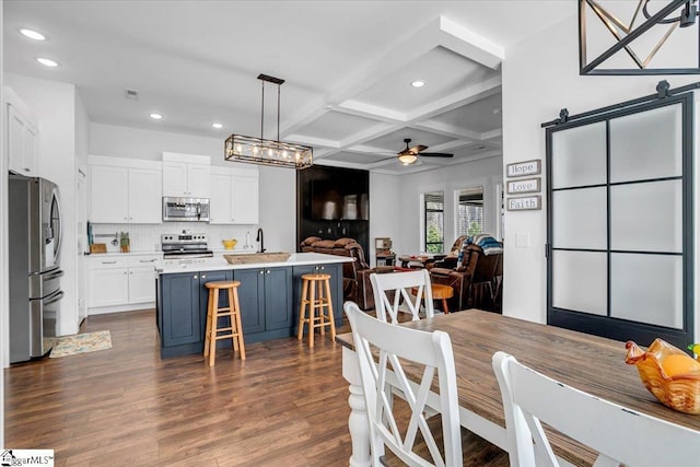 dining area with recessed lighting, dark wood-type flooring, coffered ceiling, a ceiling fan, and beam ceiling