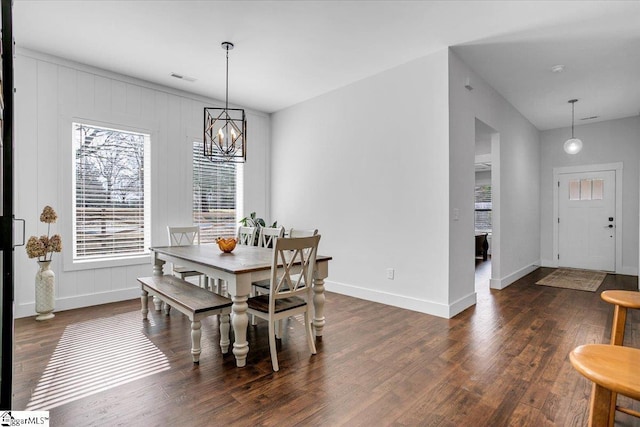 dining area with an inviting chandelier, visible vents, baseboards, and wood finished floors