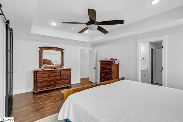 bedroom with baseboards, a tray ceiling, wood finished floors, and recessed lighting