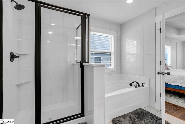 ensuite bathroom with a garden tub, a shower stall, and connected bathroom