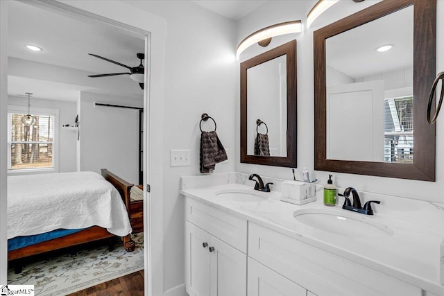 bathroom featuring ensuite bathroom, ceiling fan, wood finished floors, and a sink