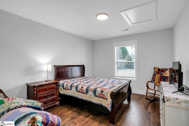 bedroom with dark wood-style floors, visible vents, attic access, and baseboards