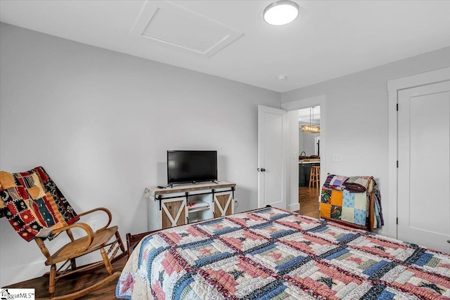 bedroom with attic access and wood finished floors