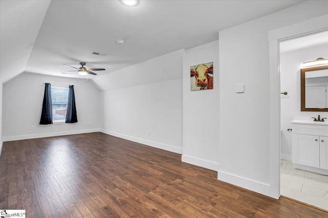 bonus room featuring lofted ceiling, visible vents, ceiling fan, wood finished floors, and baseboards