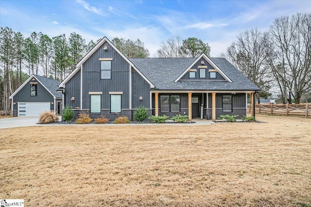 view of front of home featuring covered porch, roof with shingles, fence, and a front lawn