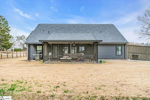 back of property featuring a shingled roof, a sunroom, and fence